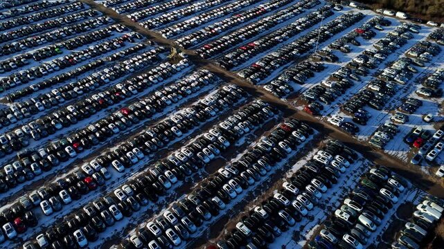 Aerial view of symmetrical rows of cars and vehicles in car storage facility. Cars moved for import and export for customers, snowy conditions in winter in Corby, United Kingdom.