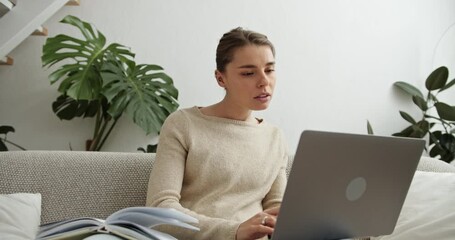 Young woman studying online using laptop at home - Powered by Adobe