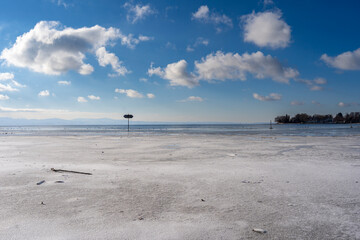 frozen bay of Lake Constance in Wasserburg Germany with blue sky and clouds