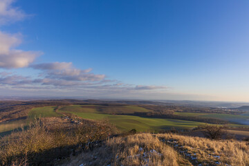 Fototapeta premium Winter panorama of Palava landscape with rolling green fields and groves. Sunny afternoon view of South Moravia, Czech Republic