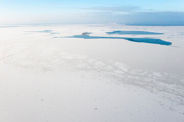 Frozen lake covered in snow, seen from a drone. Winter landscape. Lake Dabie in Poland.