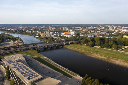 Aerial view of the Elbe River reflecting the sky, flowing beneath the Augustus Bridge, with the city's architecture spread in the distance, Dresden, Saxony, Germany.