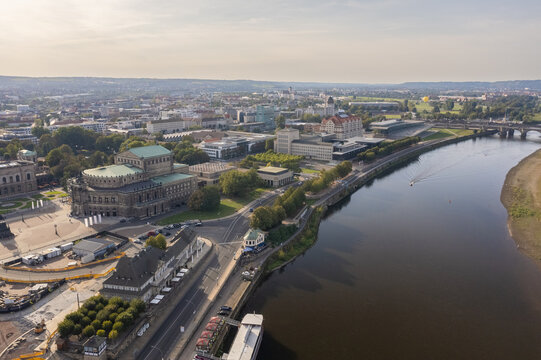 Aerial view of the Semperoper opera house and Dresden Castle reflected in the Elbe River's dark waters, a blend of history and nature, Dresden, Saxony, Germany.