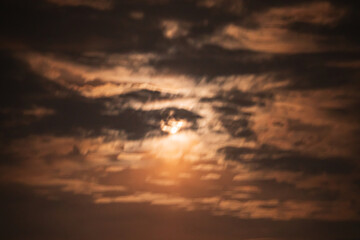 Obraz premium Moonlight filters through dark clouds at twilight, creating a mystical scene