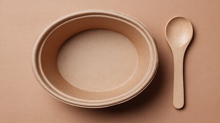 Top-down view of a disposable bowl and wooden spoon, both on a solid tan background