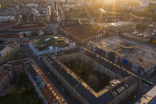 Aerial view of golden light bathing the urban landscape, illuminating rooftops and streets in a symphony of amber hues, Malmo, Scania county, Sweden.