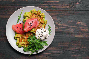 Healthy breakfast with green spinach vegetable waffles, salmon, cream cheese and arugula
