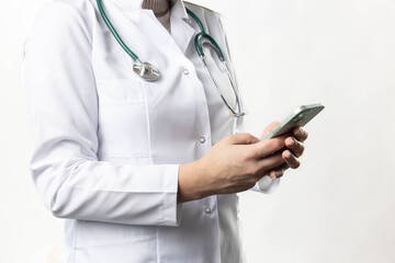 A focused doctor checking their smartphone, merging technology with modern healthcare practices.  Cropped photo of doctor hand while holding phone