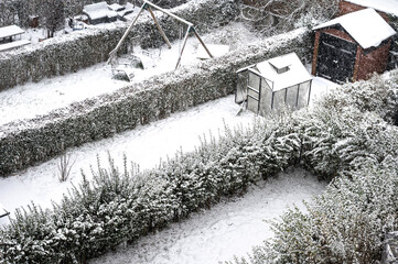 Snow-covered gardens in urban housing development