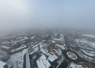 Aerial View of Snowy Cityscape Under Foggy Sky