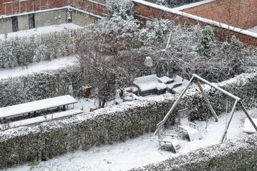 Snow-covered gardens in urban housing development