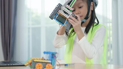 Young girl engineer working on robotics project in a STEM education class. child is focused on assembling and learning about a small robot or electronic project. engineering, innovation, technology. - Powered by Adobe