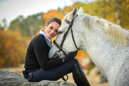  View on a woman rider with her horse in  forest