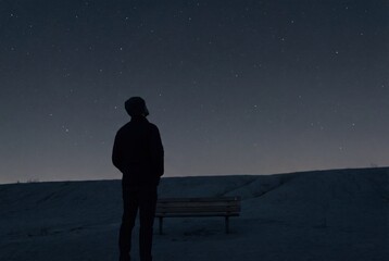 Silhouette of person watching starry night sky over hills