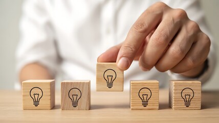 Choosing the Best Idea: Hand Lifts a Lightbulb Block for Innovation