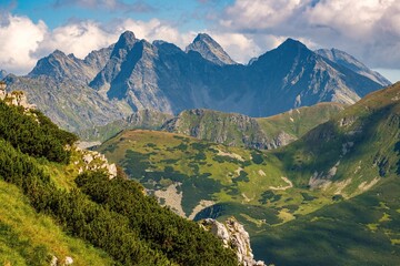 Fototapeta premium Scenic peaks of the High Tatras mountain range rising above green alpine valleys on the border of Poland and Slovakia. Iconic European mountain destination for travel, hiking, adventure, and nature ex