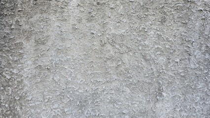 Obraz premium High-detail grey rough plastered wall texture with visible small sand and aggregate. Background of rough, uneven cement plaster with grainy texture. Provides a raw, industrial, or loft-style feel.