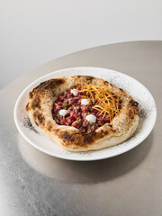 Bistroinspired pizza with mozzarella and crispy shoestring garnish