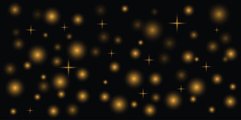 Golden glowing orbs and starbursts scattered on a black background abstract bokeh