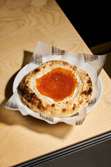Clean And Minimalistic Wooden Counter Featuring Colorful Toppings On Neapolitan Style Pizza