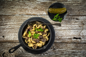 Italian pasta shells with beef sauce in cast iron pan.