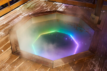 Rustic hot tub, Snowdusted cedar deck surrounds glowing hot tub