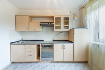 Bright Modern Kitchen Interior with Wooden Cabinets and Large Windows