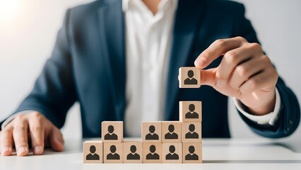 Businessman building a team hierarchy with wooden blocks
