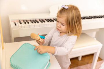 Toddler girl playing with wooden hairdryer toy