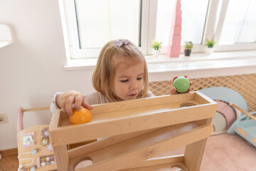 Toddler girl playing with the gravity wooden ball toy
