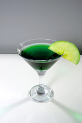 Sophisticated green apple martini with fresh slices on vibrant green closeup shot