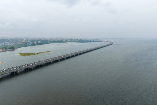 Aerial view of the Third Mainland Bridge stretches across the water under a muted sky, connecting distant shores, Yaba, Lagos, Nigeria.