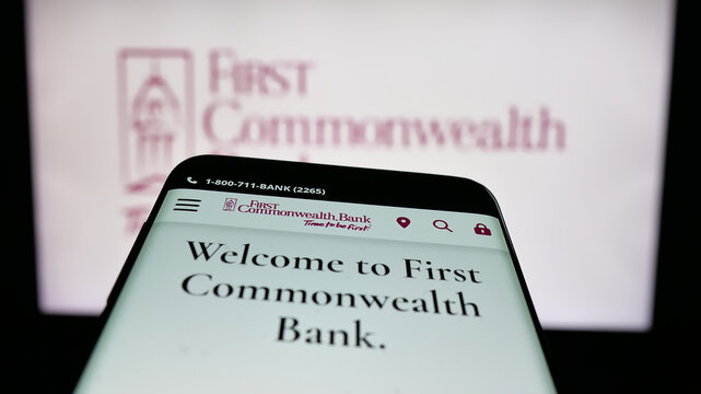 Stuttgart, Germany - 12-18-2025: Mobile phone with website of US financial company First Commonwealth Bank on screen in front of logo. Focus on top-left of phone display.