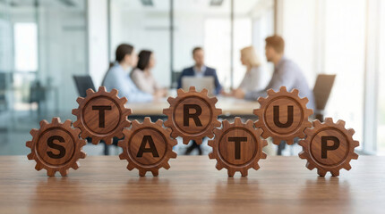 Gears form the word startup in a meeting room where a team collaborates. This scene illustrates teamwork and innovation during a business launch
