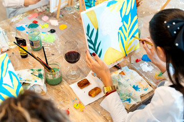 Woman painting canvas art at a relaxed sip and paint event