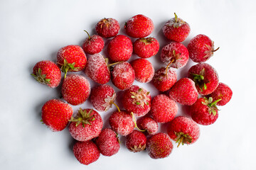 Top view of scrumptious frozen strawberries glistening with icy crystals. The vibrant red berries...