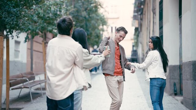 Young multicultural friends getting lost and arguing in a city street. Group of people trying to find their way using a map on a smartphone