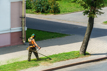 a man mows the grass. The lawn mower uses special equipment to mow the grass. A man in special...