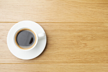 Obraz premium Aromatic coffee in cup on wooden table, top view. Space for text