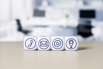 Contact icons on cubes representing communication channels in a modern office environment