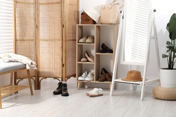 Fototapeta premium Shoe storage with different footwear and accessories indoors