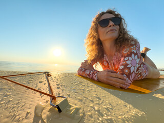 Young woman walking on stand up paddle sup boards by the sea during summer vacation