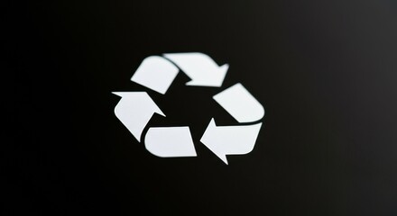 Recycling symbol in white on dark surface representing circular sustainability