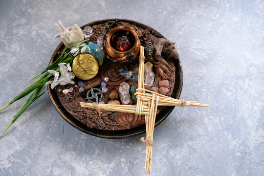 Wiccan altar for Imbolc sabbat. witchcraft, pagan magic ritual. Brigid's cross amulet of straw, wheel of the year, snowdrops, goat decor, cauldron on table. Imbolc holiday, spring equinox. top view