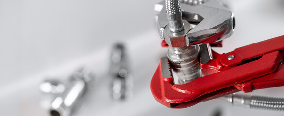 Plumber screws a water pipe fitting. Plumbing services and repairs. banner with copy space