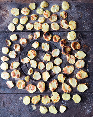 Roasted potato slices on rustic metal stove top