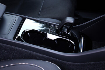  Close up of the automatic gearbox lever. Close up cup holders and Selector automatic transmission. Cup holders inside modern car interior. Car inside.