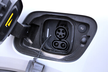 Close-up of an open electric vehicle charging port showing both AC and DC connectors, emphasizing dual charging options for versatile energy solutions