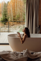 Enjoying a relaxing moment in a modern bathtub with a cup of tea