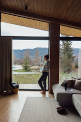 Cozy indoor scene with a woman relaxing and working on a laptop